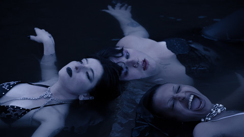 Drei Personen liegen im Wasser