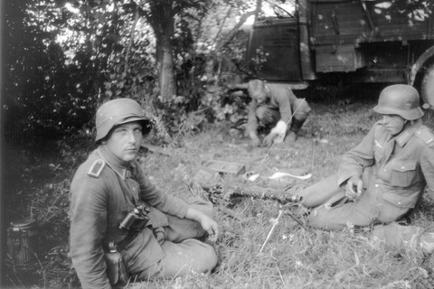 Historisches Bild eines Soldaten, der mit seinen Kameraden auf dem Boden sitzt