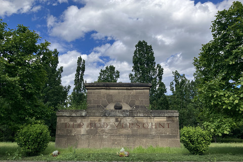Blick auf ein großes Grab mit der Aufschrift "Der Tod versöhnt"