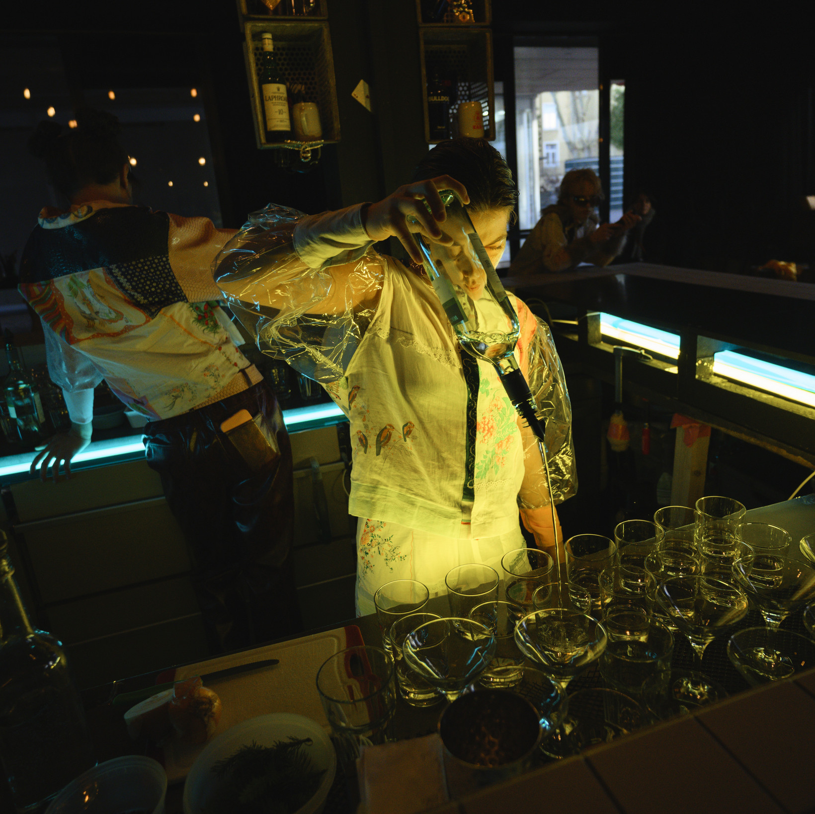 Person hinter einer Bar schenkt Getränke ein