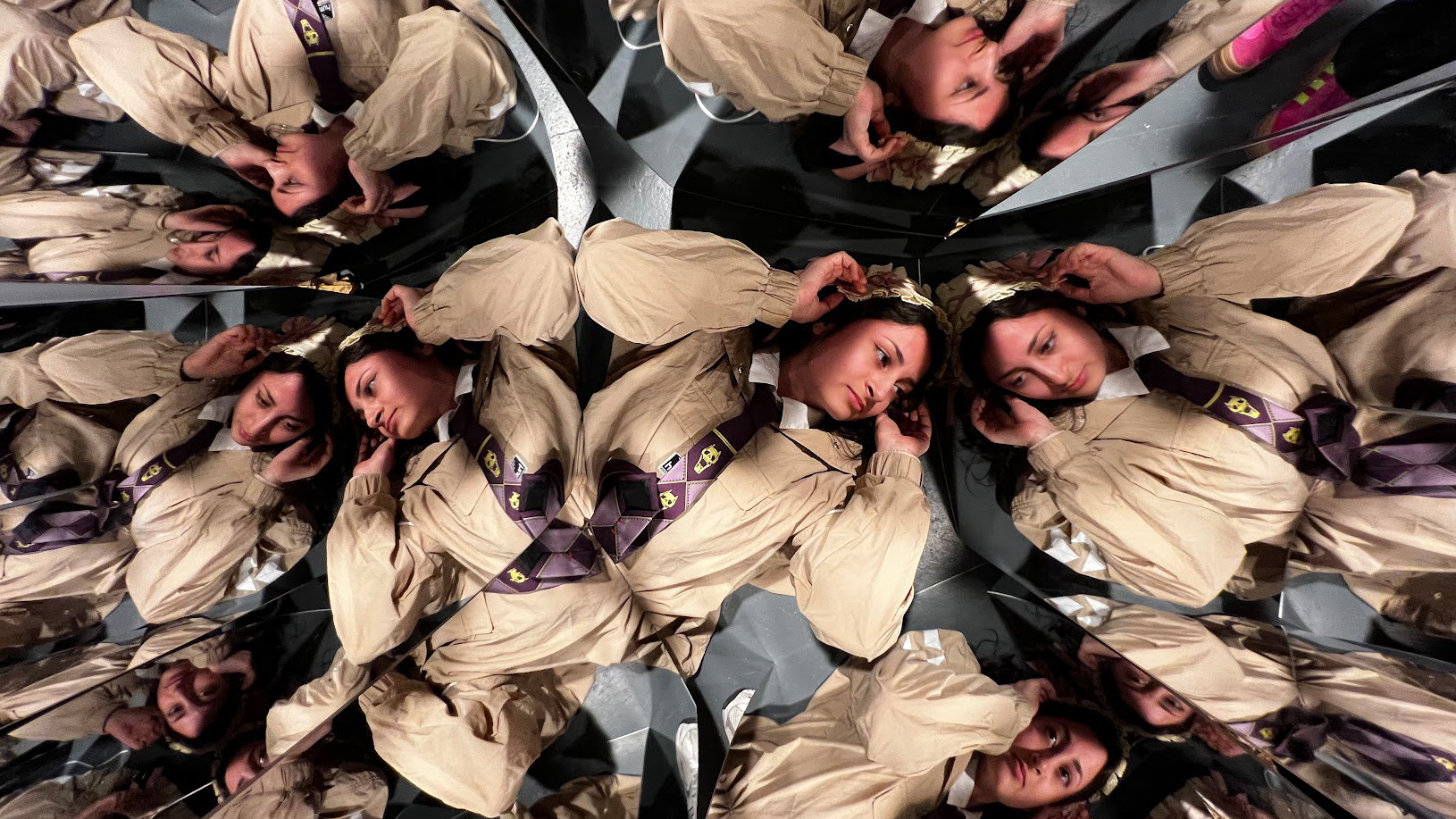 A person, flying on the floor, looking in mirrors that multiply their counterfeit.