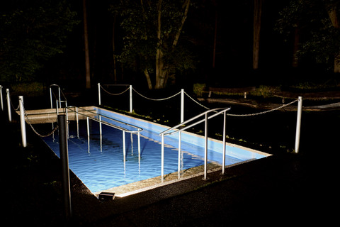 Bild von einem blau erleuchteten Swimming Pool in der Nacht