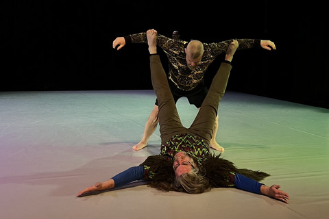 one person carrying another with their feet