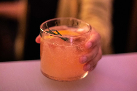 Hand hält ein Glas mit einem Cocktail