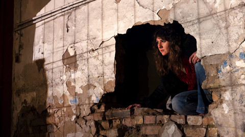 Person kommt aus einem Loch in der Wand