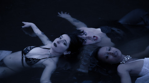 Drei Personen liegen im Wasser