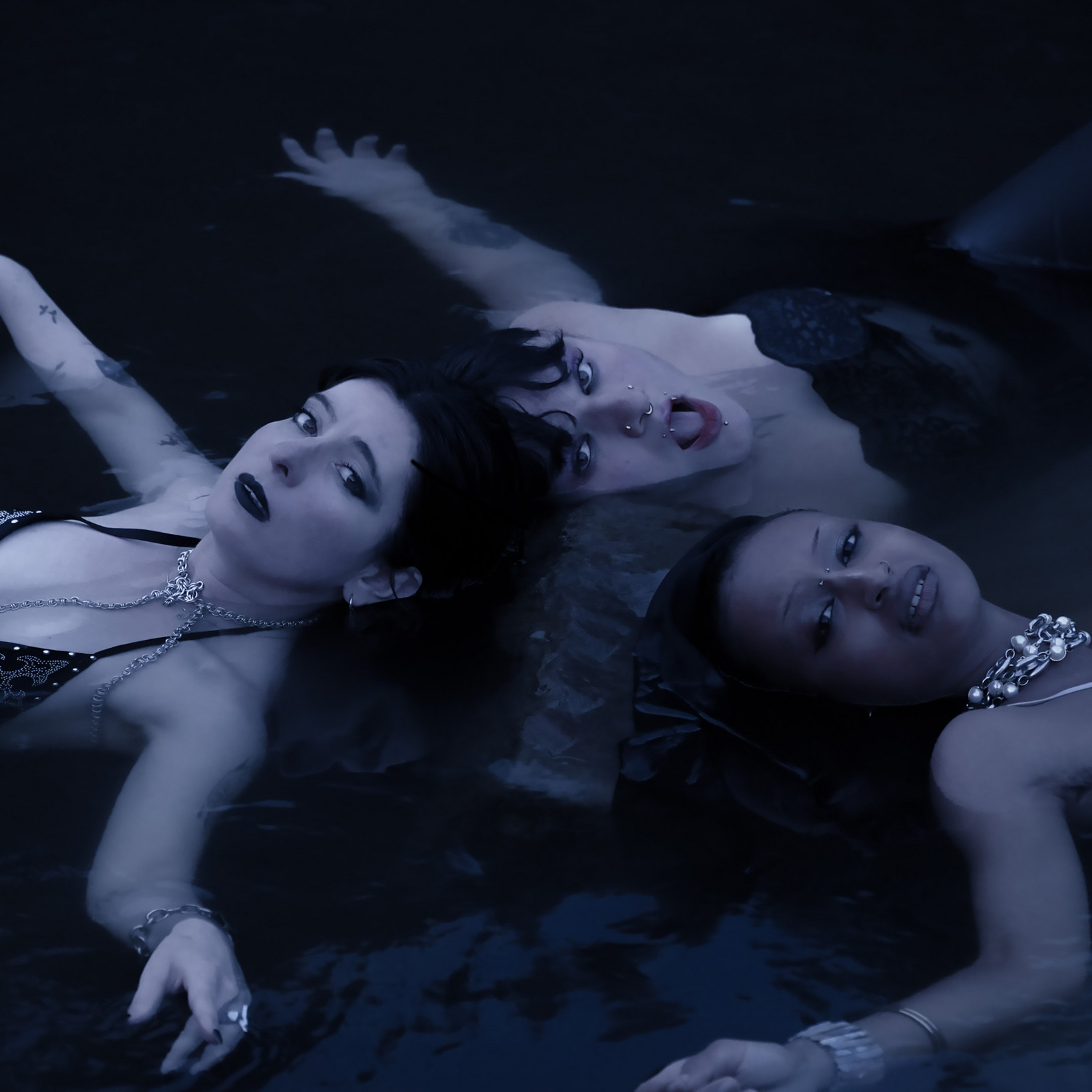 Drei Personen liegen im Wasser
