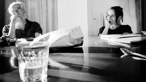 Schwarz-weiß Bild von zwei Personen, die an einem Tisch sitzen und sich unterhalten