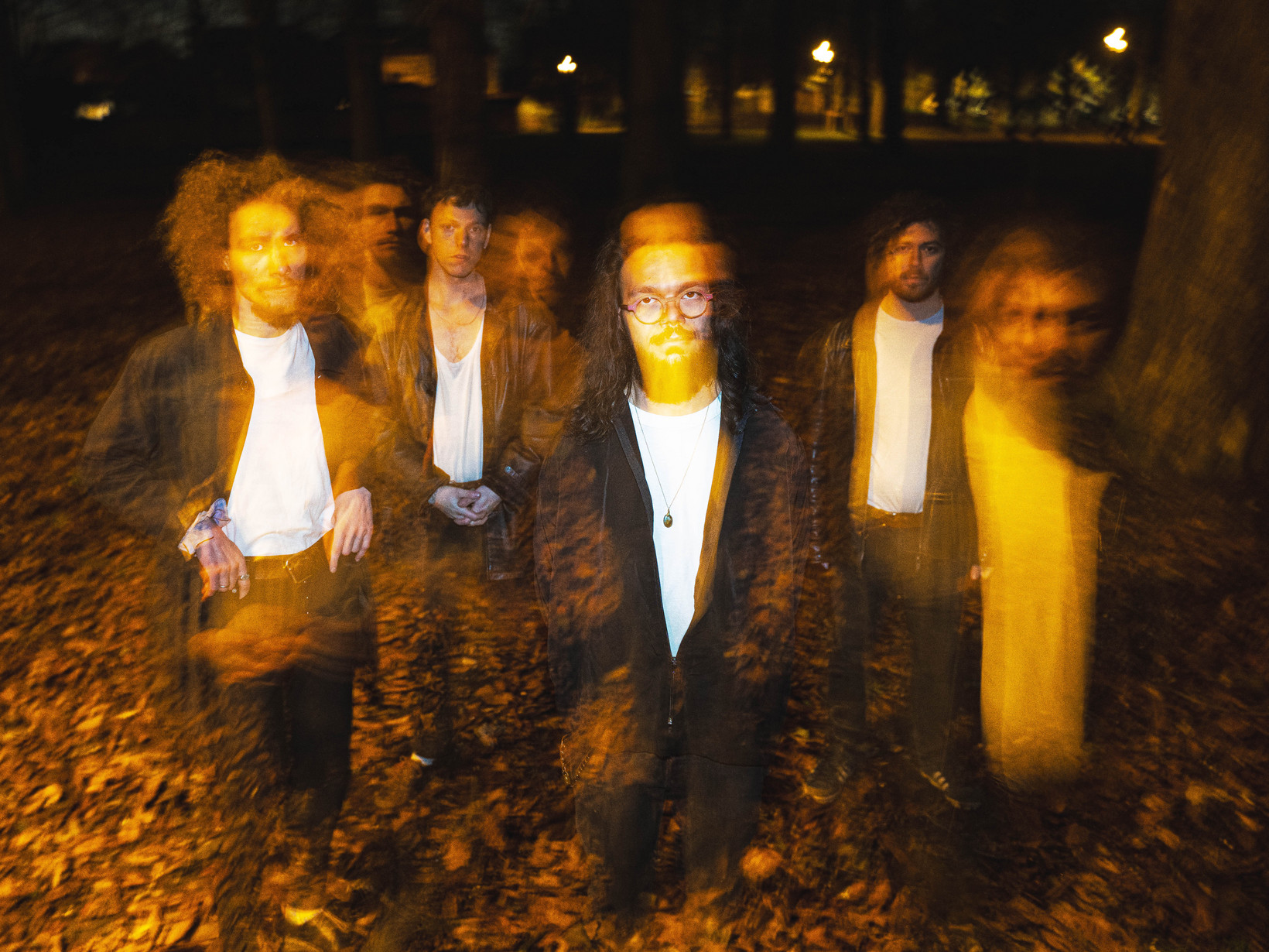 verschwommenes Bild von vier Personen, die draussen auf einem Boden voller Blätter stehen