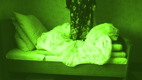 Person steht auf einem Bett.