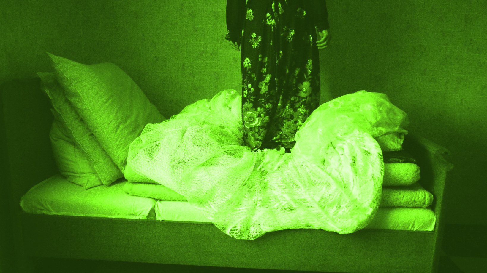 Person im Kleid steht in einem Bett, das Bild hat einen grünstich.