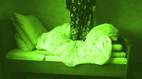 Person steht auf einem Bett
