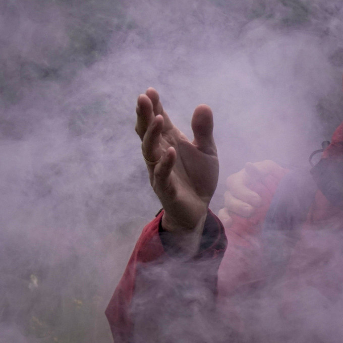 Hand streckt sich aus dem Rauch