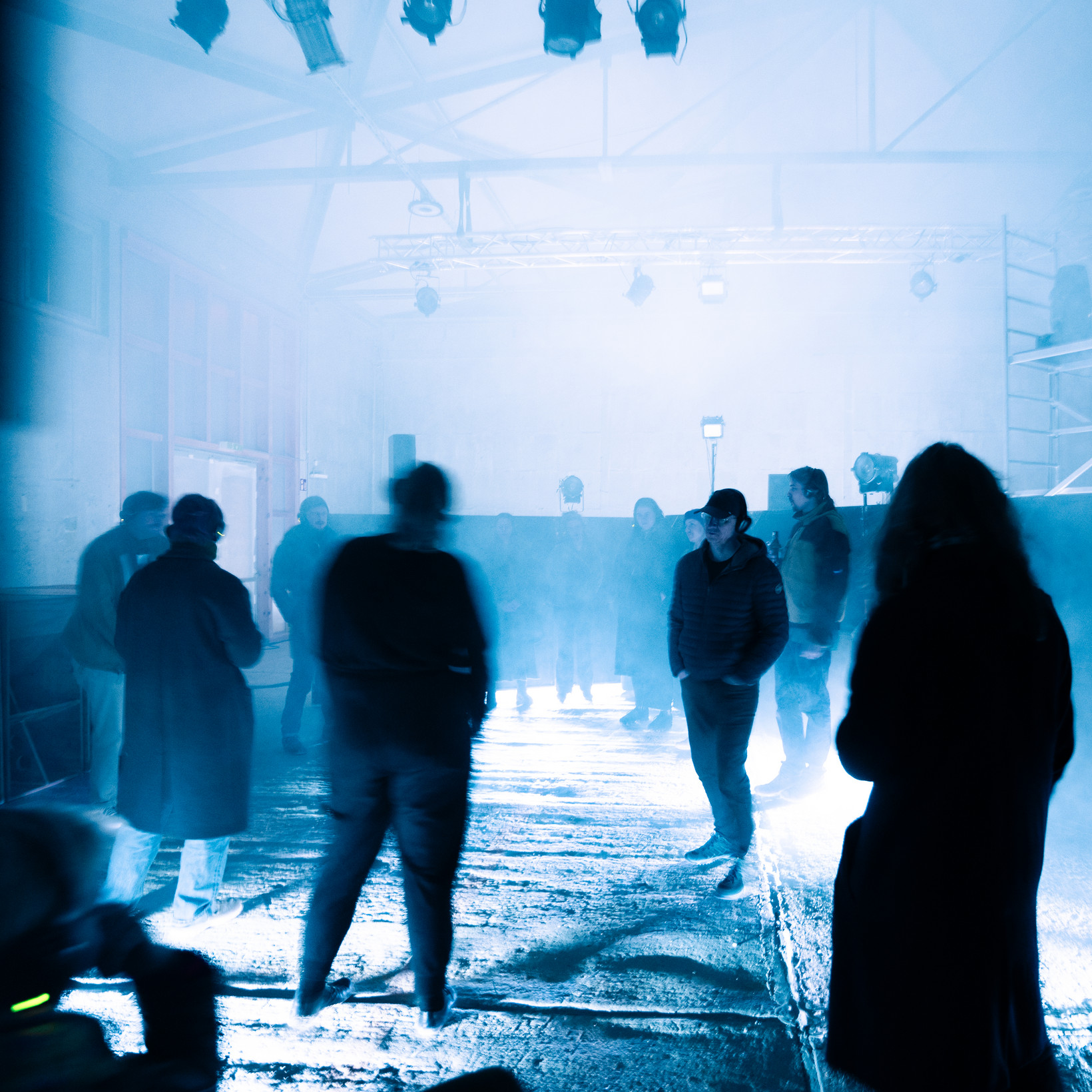 blau beleuchteter Raum, in dem Menschen tanzen