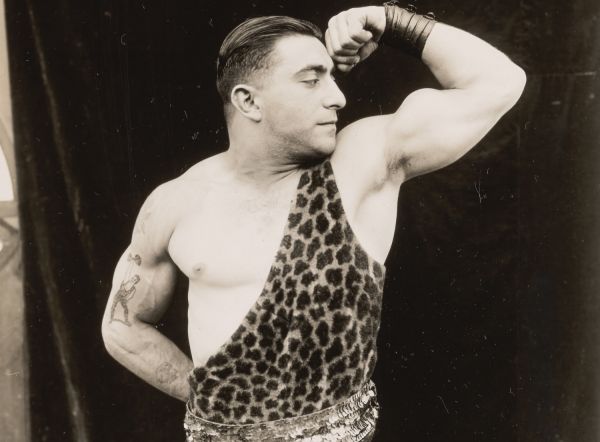 Männerphantasien historisches Foto eines Mannes im Leoparden-Anzug, der seine Muskeln zeigt